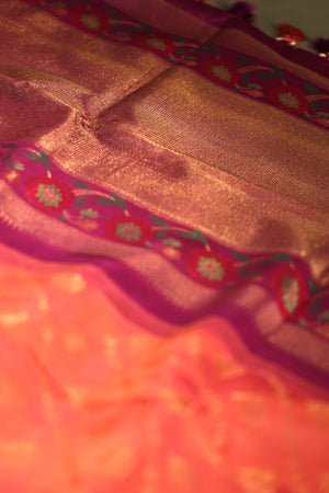 A beautiful kanjeevaram saree in peach with resham thread work floral border