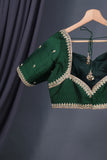 A designer kanjeevaram saree in bottle green with hues of pink border and pallu
