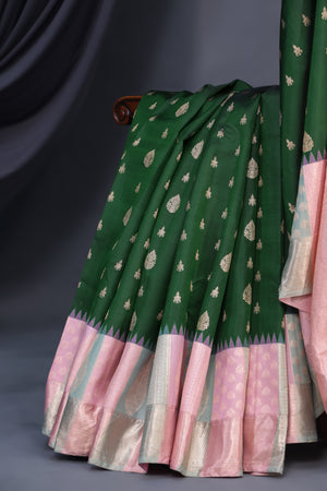 A designer kanjeevaram saree in bottle green with hues of pink border and pallu