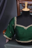 A designer kanjeevaram saree in bottle green with hues of pink border and pallu