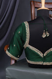 A designer kanjeevaram saree in bottle green with hues of pink border and pallu