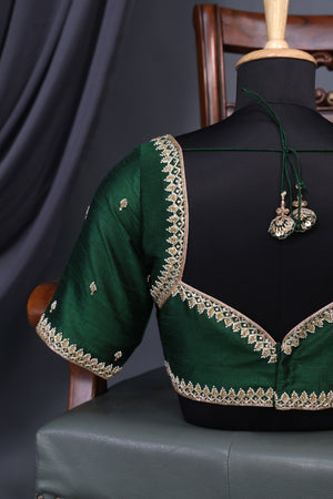 A designer kanjeevaram saree in bottle green with hues of pink border and pallu