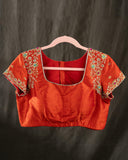 Mustard yellow organza saree with a contrast orange blouse