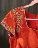 Mustard yellow organza saree with a contrast orange blouse