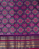 Orange twill Patola saree with a contrast purple border