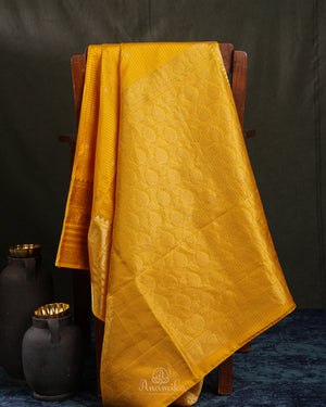 Kanchi soft silk saree in yellow paired with a contrast orange blouse