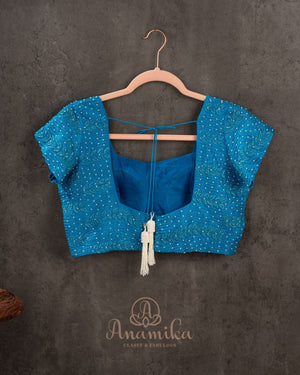 A Bandini Georgette saree in hues of blue paired with a blue pearl work blouse