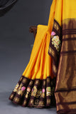 Yellow Gadwal Pattu saree with brown border and tanjore painting