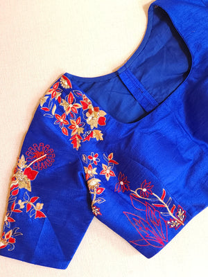 Red organza saree with a contrast blue work blouse