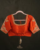 Kanchi soft silk saree in yellow paired with a contrast orange blouse