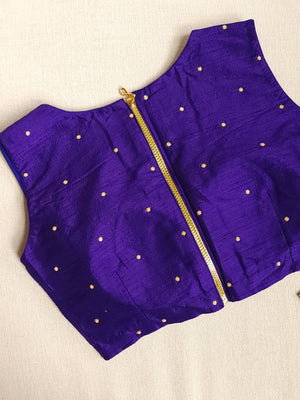 A purple sleeveless blouse with gold embroidery