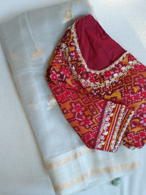 Flowy Malai silk saree in grey paired with a red Patola blouse