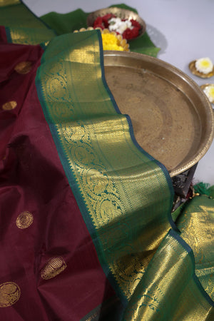 An exquisite kanjeevaram saree in deep maroon and emerald green combo