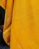 Kanchi soft silk saree in yellow paired with a contrast orange blouse