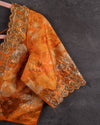 Crushed Tissue Saree in peach paired with a floral work blouse