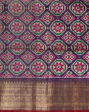 Orange twill Patola saree with a contrast purple border