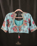 A beautiful Floral blouse in pastel blue with intricately designed embroidery