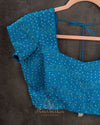 A Bandini Georgette saree in hues of blue paired with a blue pearl work blouse