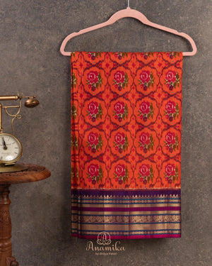 Orange twill Patola saree with a contrast purple border