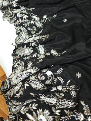 A pure crepe saree in black with stunning silver embroidered border