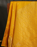 Kanchi soft silk saree in yellow paired with a contrast orange blouse
