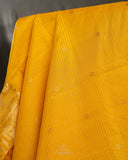 Kanchi soft silk saree in yellow paired with a contrast orange blouse