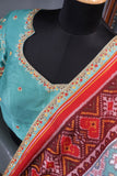 A classic patola in aqua blue with a striking contrast red