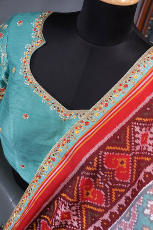 A classic patola in aqua blue with a striking contrast red