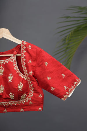 A striking red Mashru silk saree with a designer blouse
