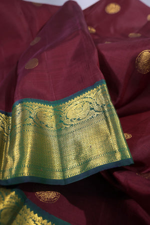 An exquisite kanjeevaram saree in deep maroon and emerald green combo