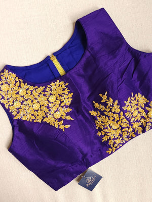 A purple sleeveless blouse with gold embroidery