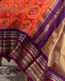 Orange twill Patola saree with a contrast purple border