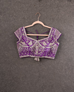 Organza saree in lovely purple with a zardosi work border and a heavily embroidered cap sleeve blouse