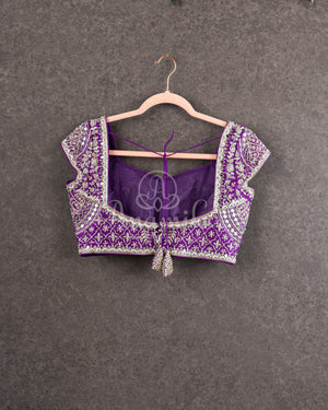 Organza saree in lovely purple with a zardosi work border and a heavily embroidered cap sleeve blouse