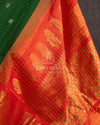 A Gadwal pattu saree in Dark Green color with a contrast orange border