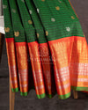 A Gadwal pattu saree in Dark Green color with a contrast orange border