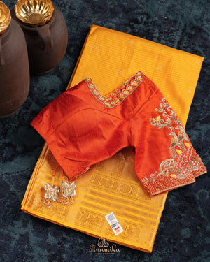 Kanchi soft silk saree in yellow paired with a contrast orange blouse