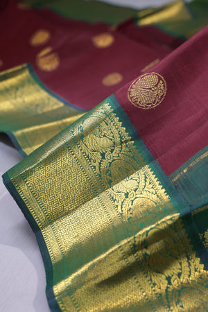 An exquisite kanjeevaram saree in deep maroon and emerald green combo