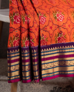 Orange twill Patola saree with a contrast purple border