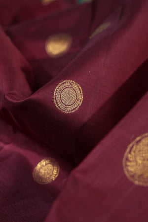 An exquisite kanjeevaram saree in deep maroon and emerald green combo