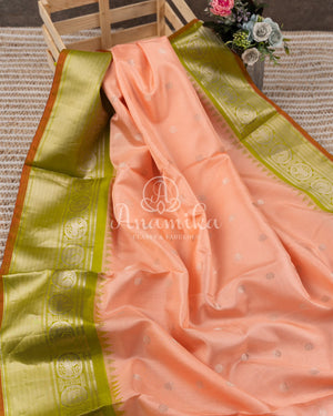 Pastel peach Pink Gadwal saree with a contrast pastel green border and blouse