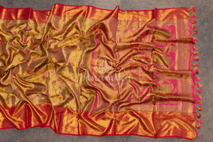 Bridal Kanjeevaram tissue saree in gold, with a contrast pink border