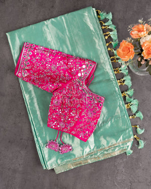 Tissue Kanjeevaram saree in light pastel blue paired with a contrast pink mirror work blouse