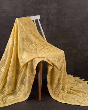 Chikankari georgette saree in yellow paired with a sleeveless off white blouse