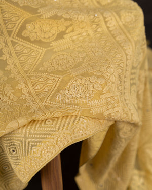 Chikankari georgette saree in yellow paired with a sleeveless off white blouse