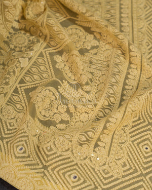 Chikankari georgette saree in yellow paired with a sleeveless off white blouse
