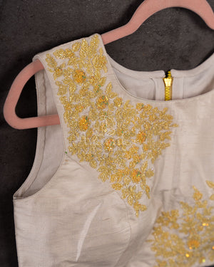 Chikankari georgette saree in yellow paired with a sleeveless off white blouse
