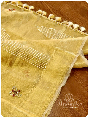 Classic gold tissue saree enhanced with hand work buttis