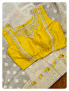 Off white organza saree with a sleeveless yellow blouse