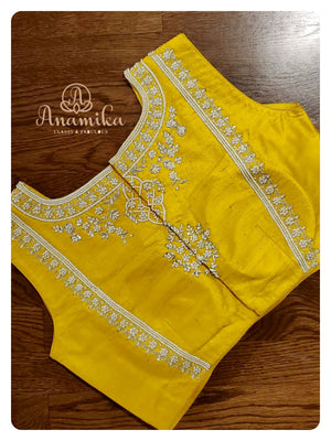 Off white organza saree with a sleeveless yellow blouse